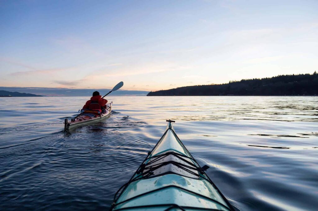 Two people kayaking in the serene waters of Squamish Sound, embodying the sense of lifestyle freedom made possible through smart mortgage solutions.