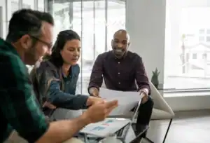 Three diverse professionals review mortgage data in a modern office—finding hidden savings with a Squamish-based mortgage broker.